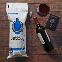 Load image into Gallery viewer, lifestyle image showing a jet bag in use on a table with a glass of wine, wine bottle and passport